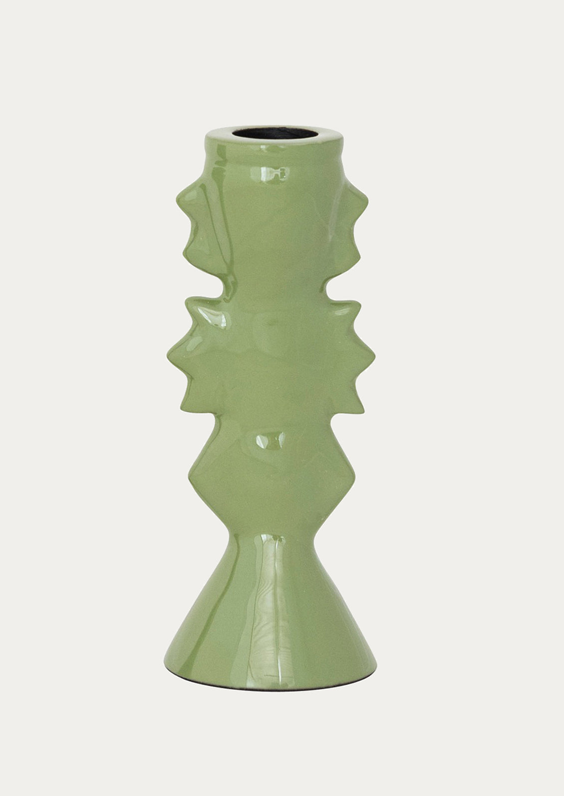 Green ceramic candleholder with geometric design on a white background