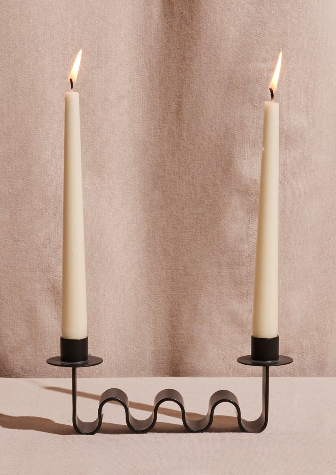 A black metal double candleholder with squiggle shape.