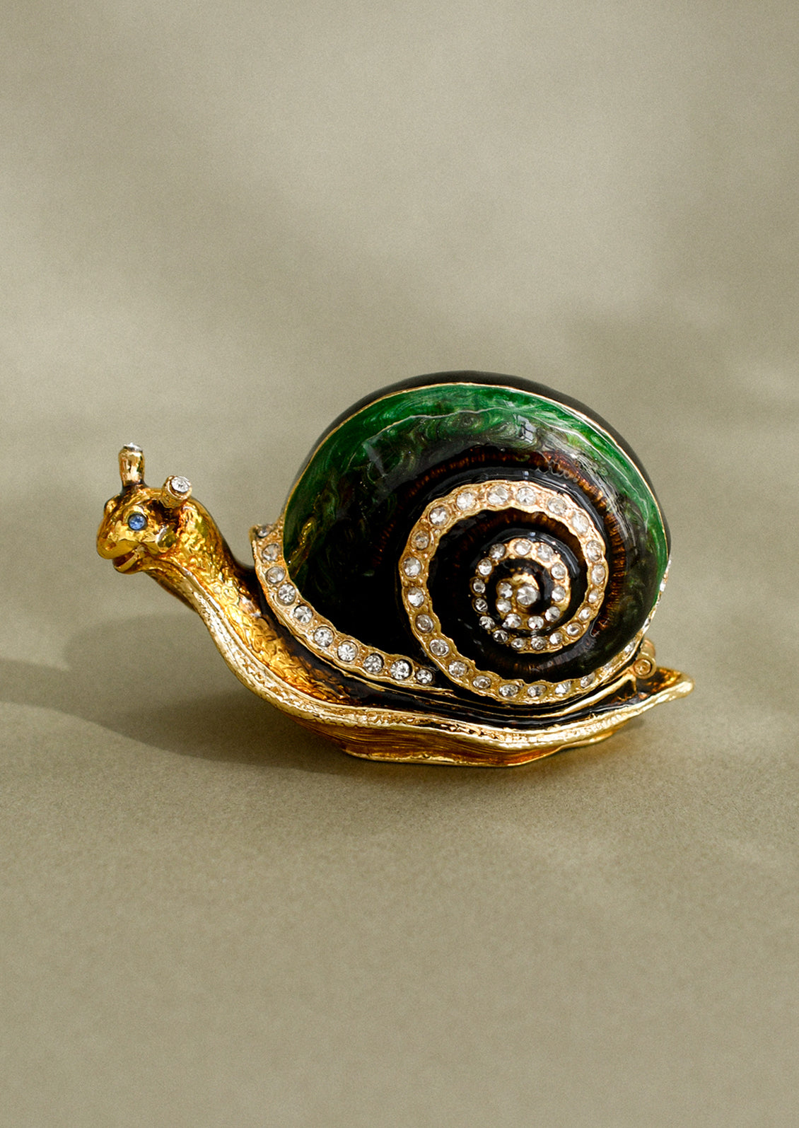 A crystal detailed metal trinket box depicting a green snail.