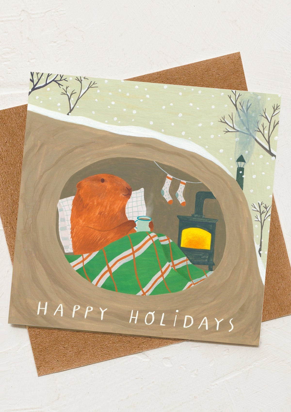 A greeting card with illustration of a groundhog sleeping inside a log.