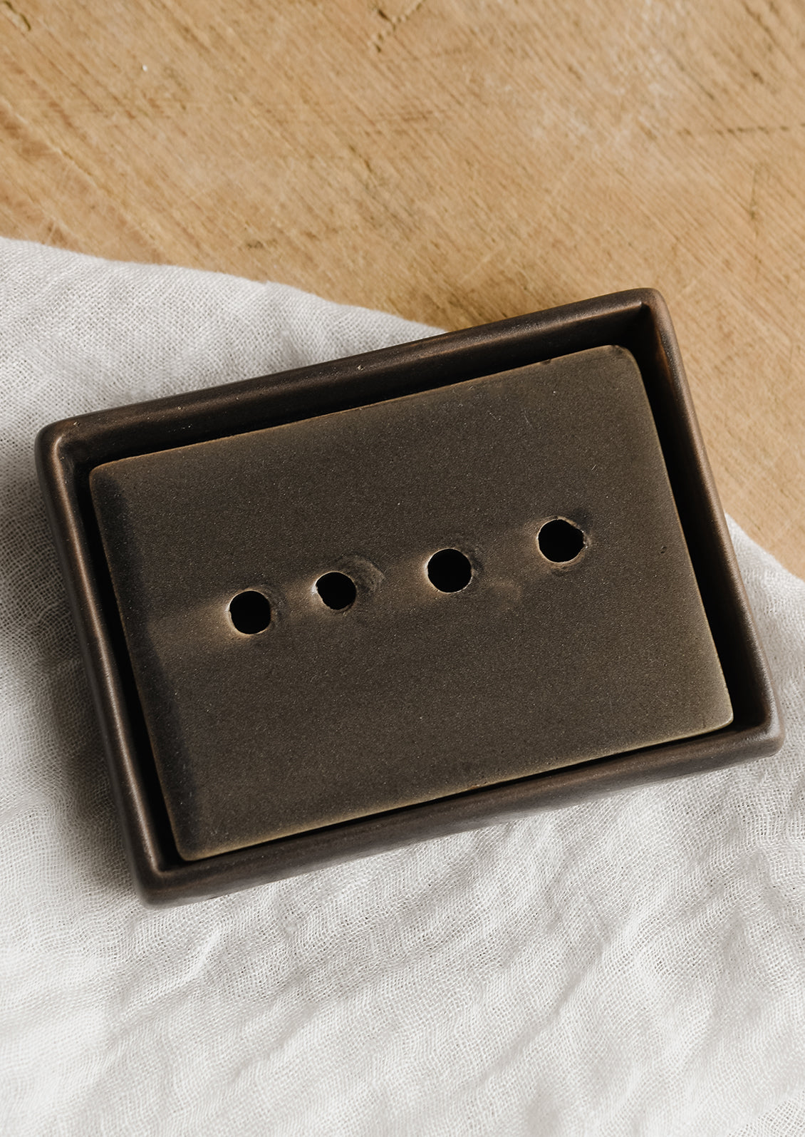 A rectangular ceramic soap dish with removable drainage tray in brown.