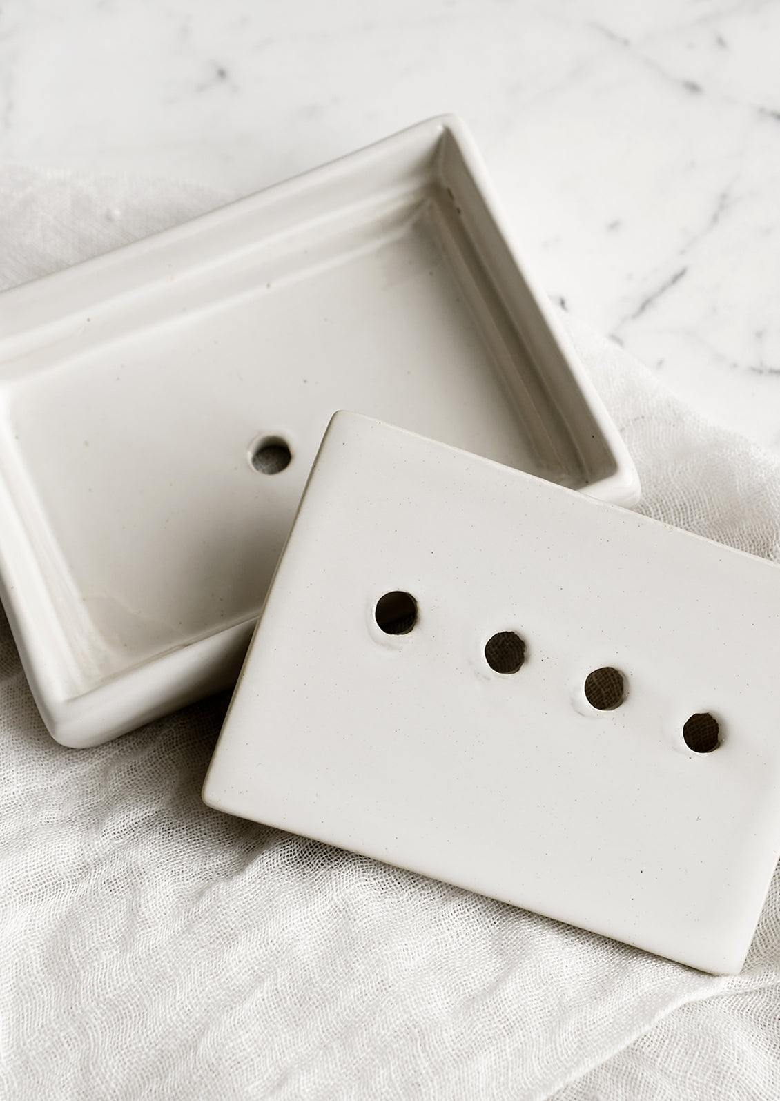 A rectangular ceramic soap dish with removable drainage tray in white.
