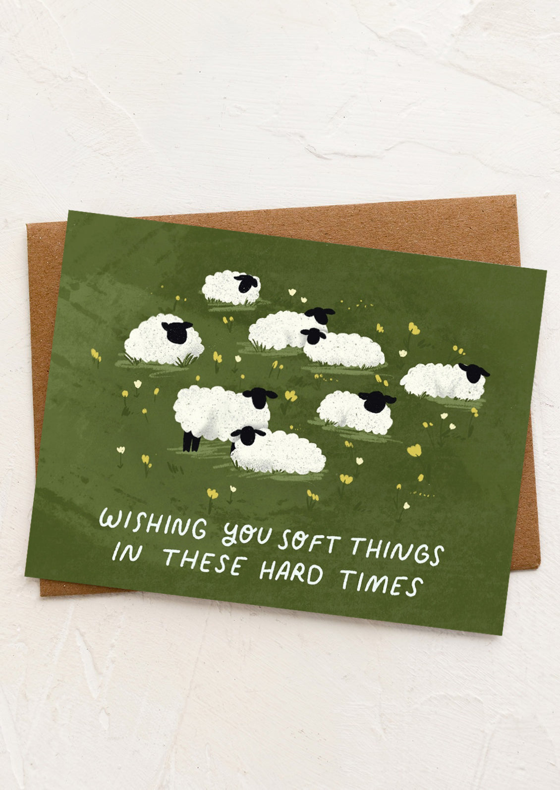 A card with illustrations of sheep, text reads "wishing you soft things in these hard times".