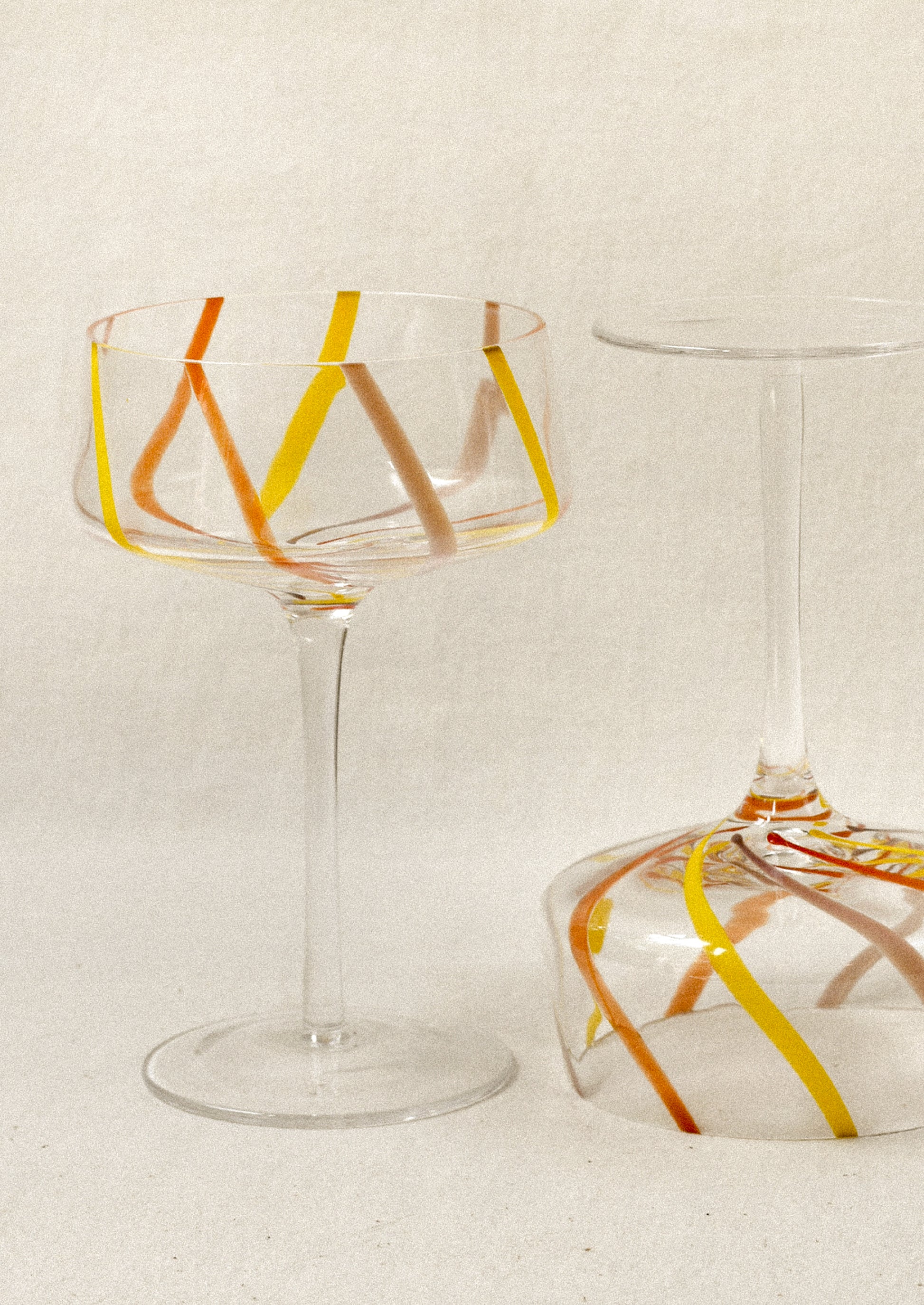 Clear coupe glass with colorful stripes.