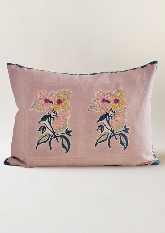 A throw pillow with lavender background and floral picture print.