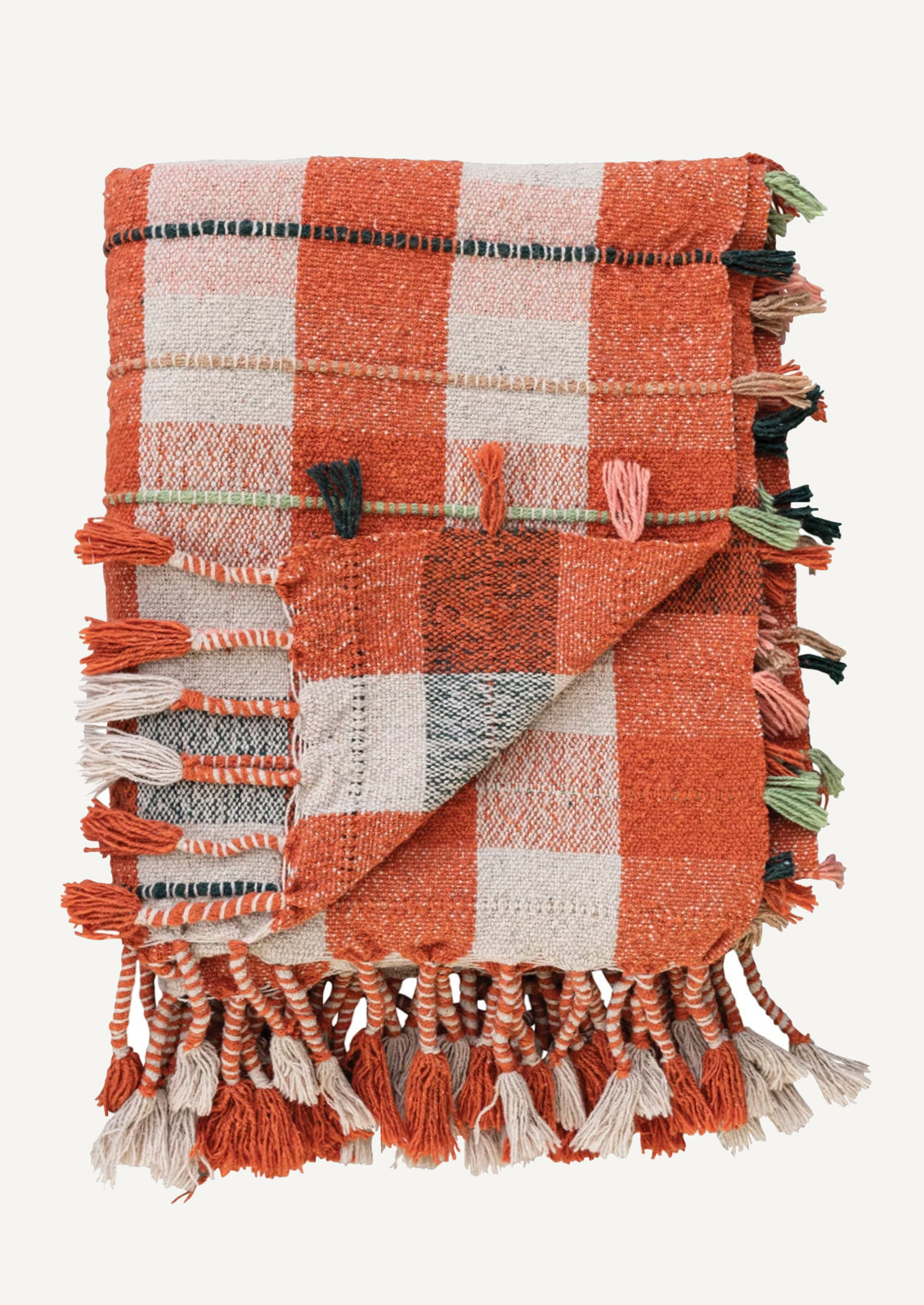 A cotton blend throw blanket in orange and cream plaid with multicolor tasseled stripe detailing.