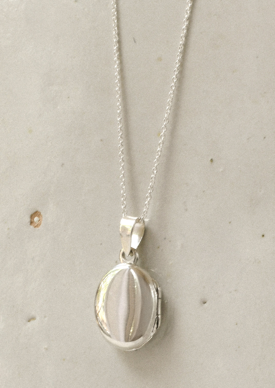 A minimal sterling silver locket.