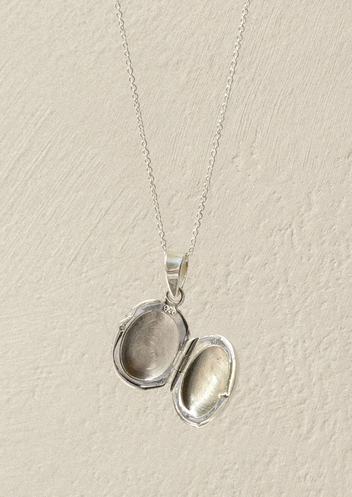 An opened sterling silver locket.
