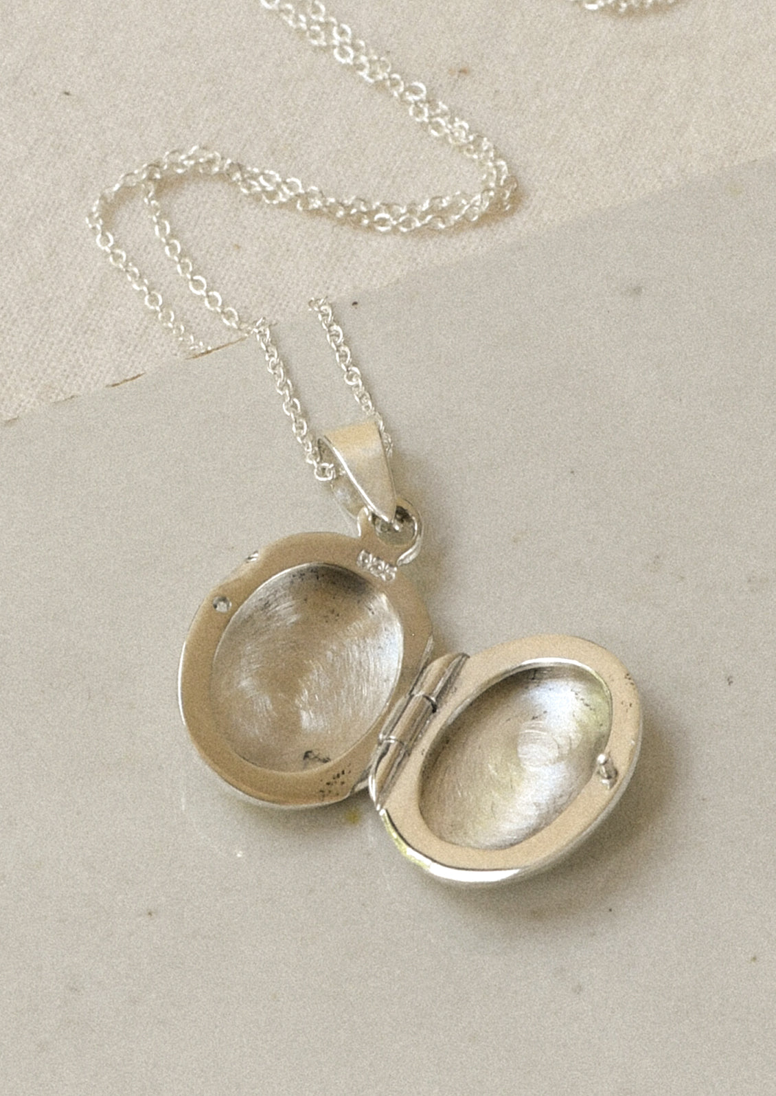 An opened sterling silver locket.