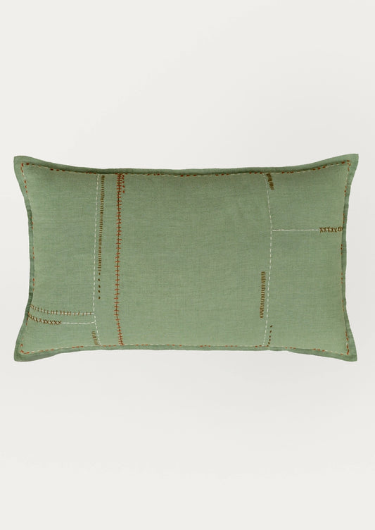A rectangular sage green lumbar pillow with a linen-like textured fabric and decorative patchwork-style stitching in contrasting orange-brown and cream thread, shown against a plain light gray background.