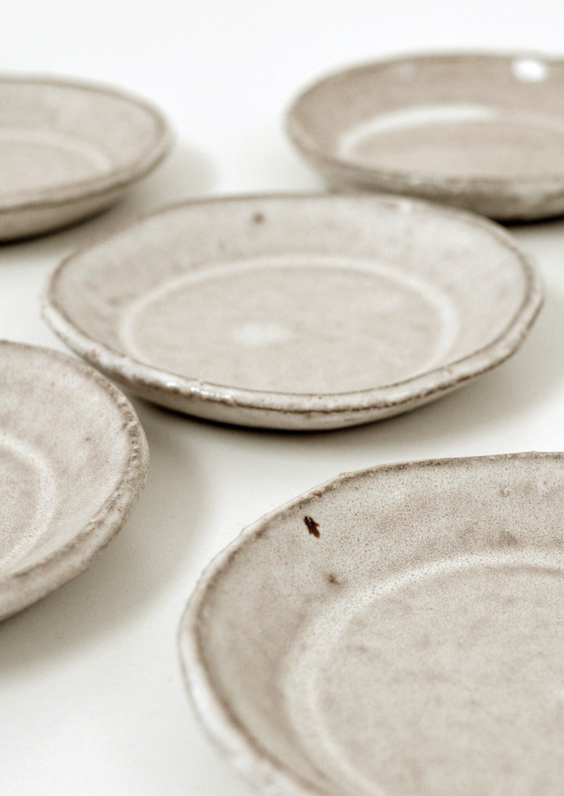 Small round stoneware plate in natural light brown glaze.