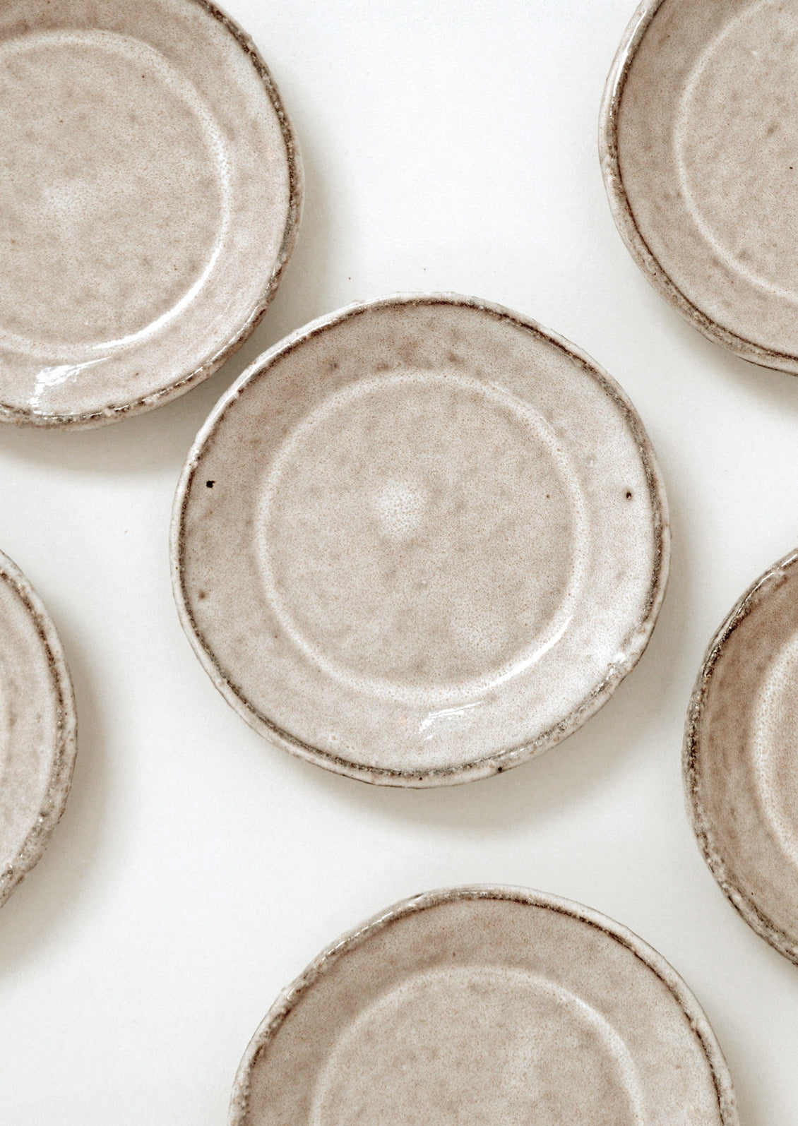 Small round stoneware plate in natural light brown glaze.