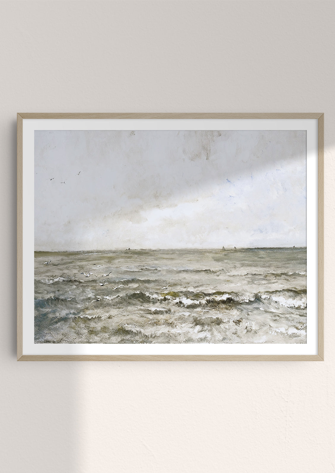 An art print of cloudy ocean painting in frame.