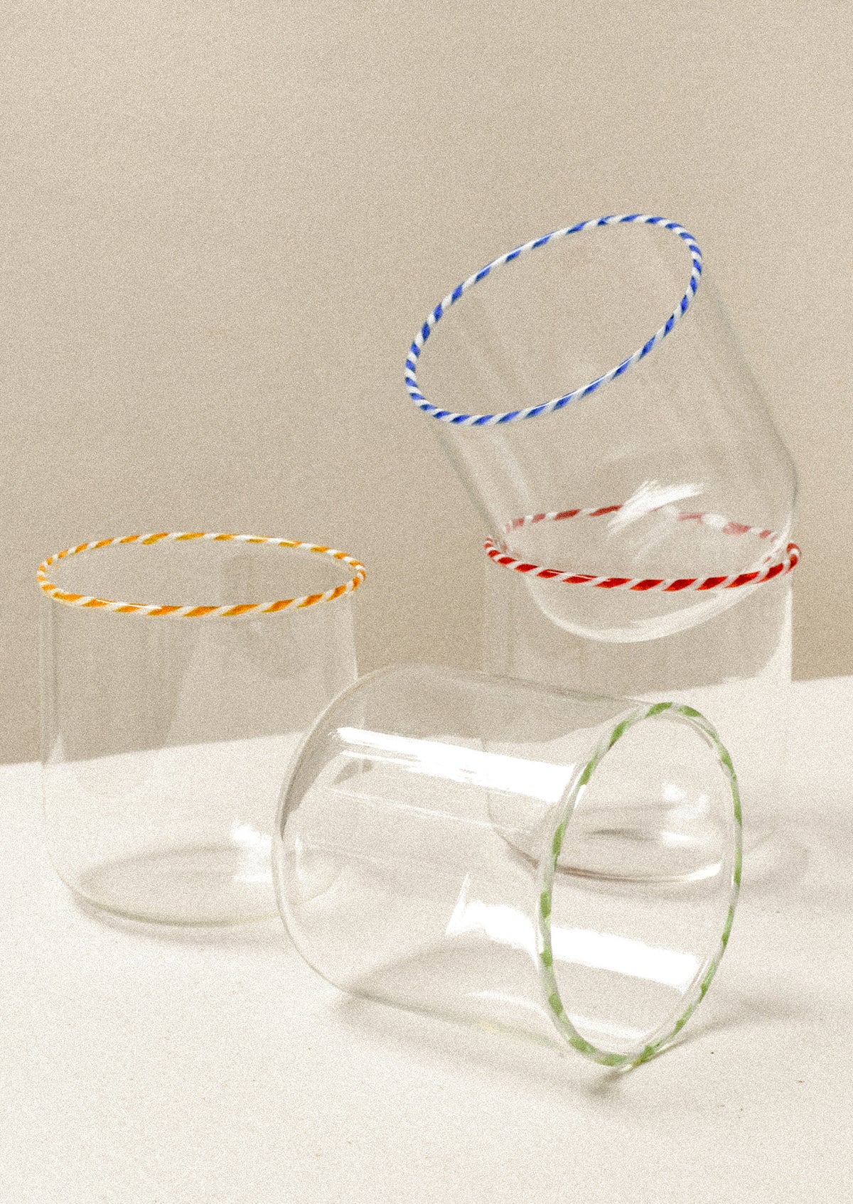 Clear glass drinking glasses with colorful striped rims