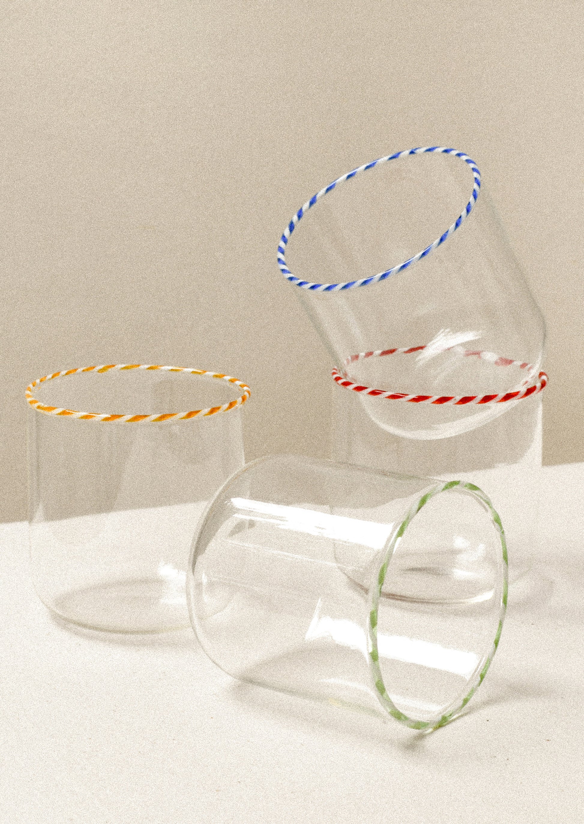 Clear glass drinking glasses with colorful striped rims