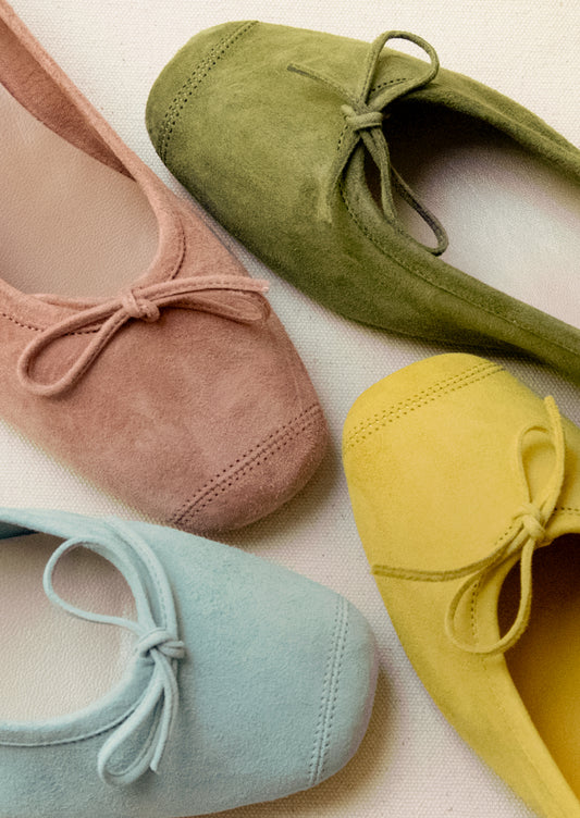 An assortment of suede ballet flats in a variety of colors.