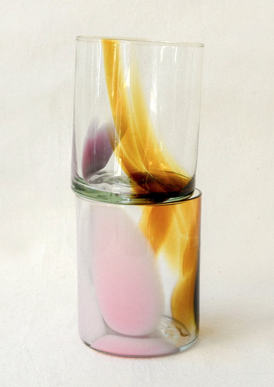 Clear glass tumblers with an abstract brown and pink design.