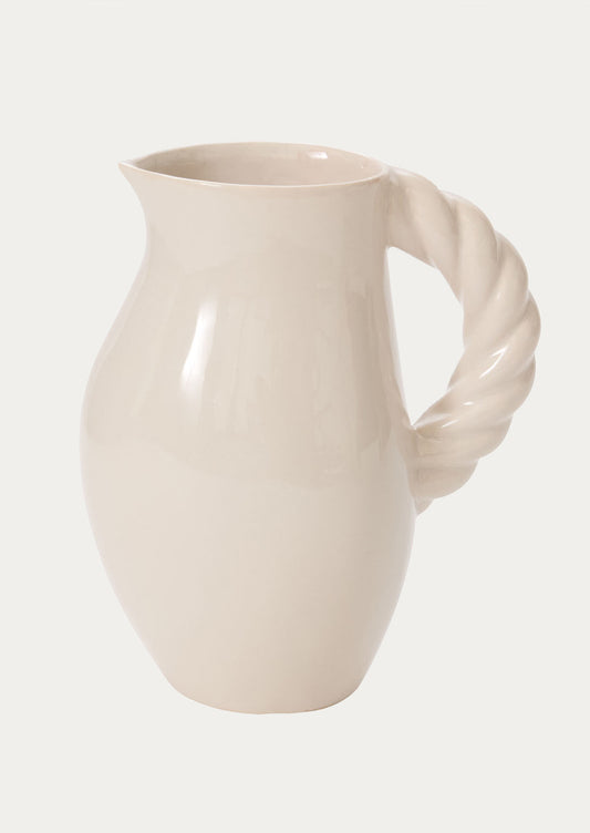 A white ceramic pitcher with braided textured handle.