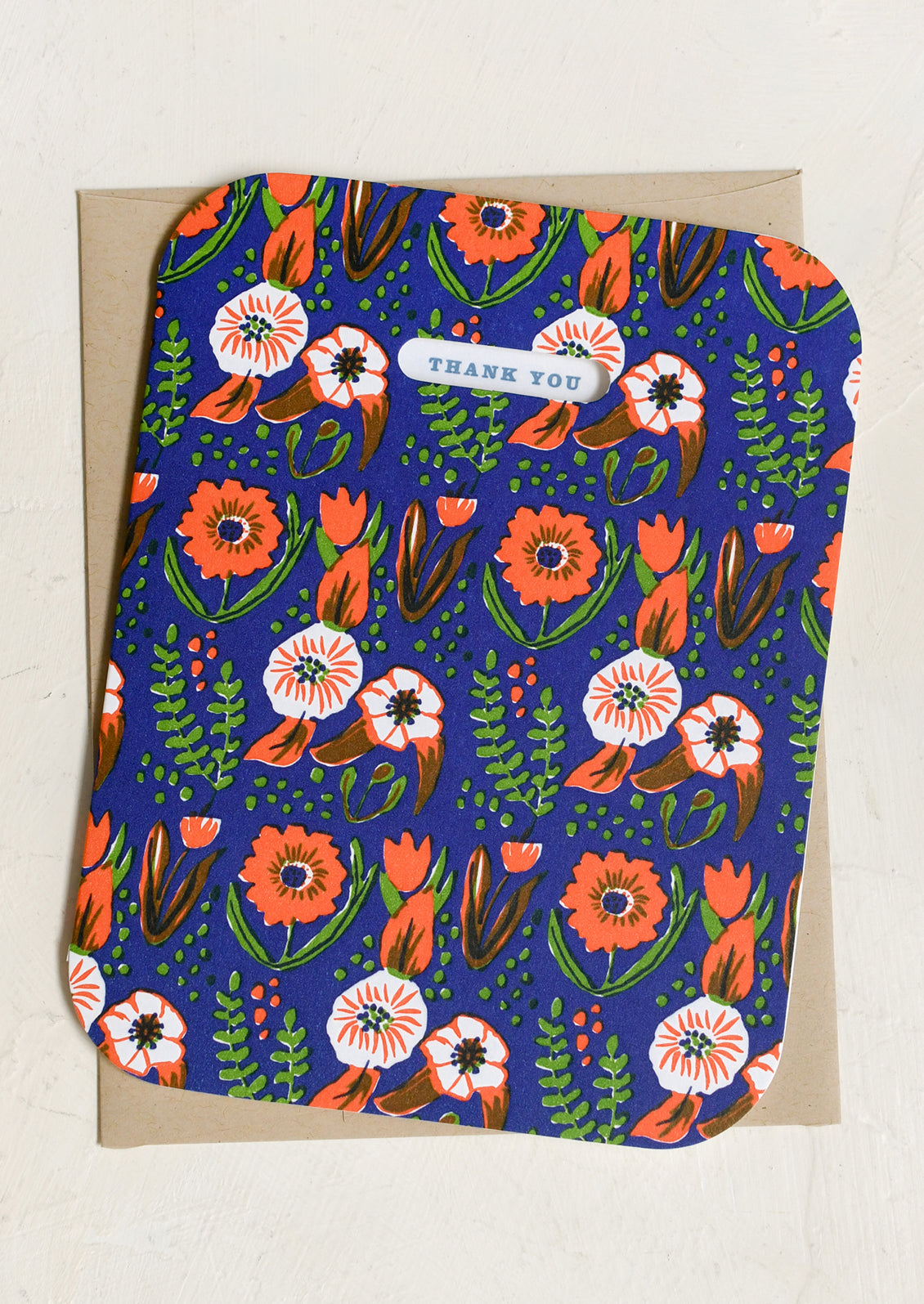 A dark blue and red floral print greeting card reading "Thank you".