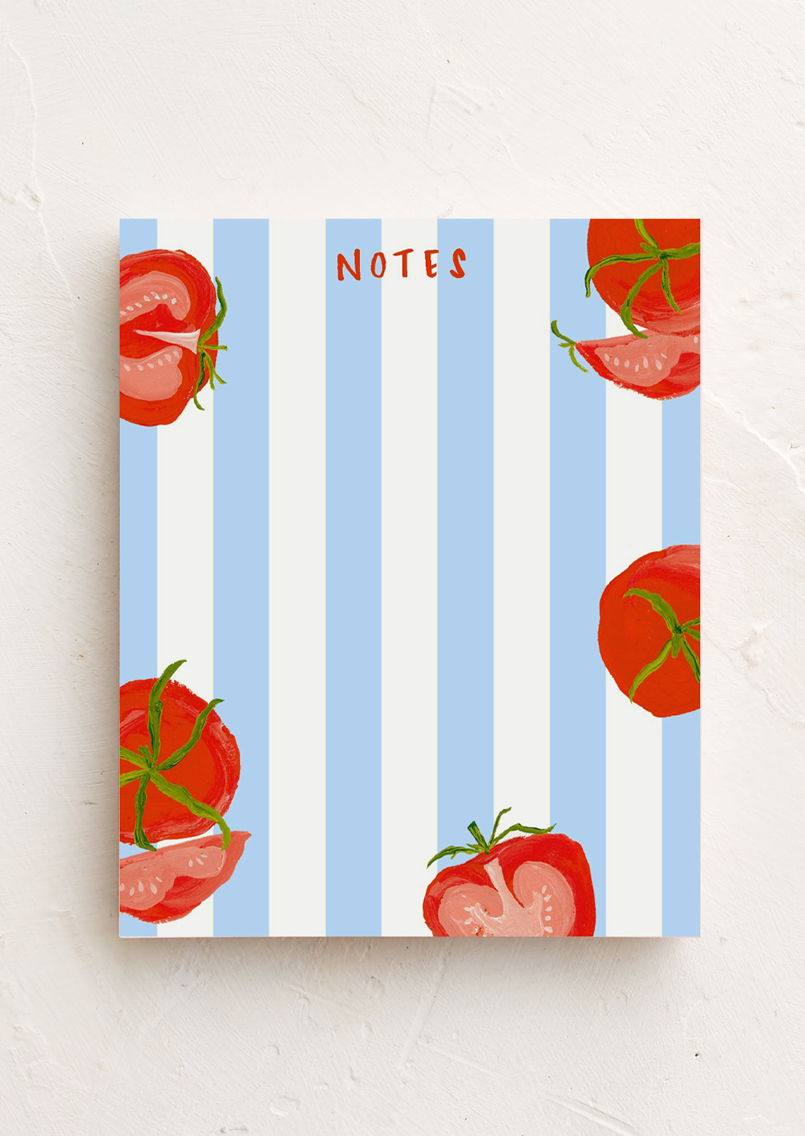A blue and white striped notepad with tomatoes at corners.