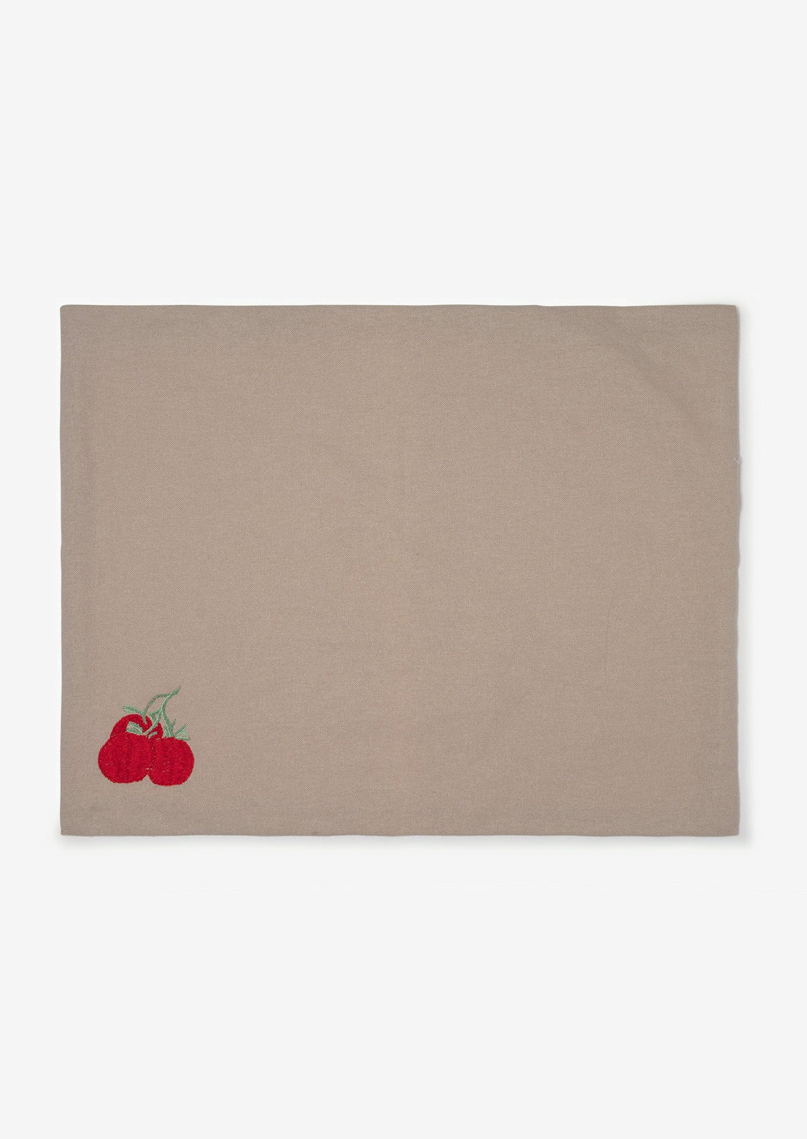 A grey cotton placemat with tomato embroidery at bottom left corner.