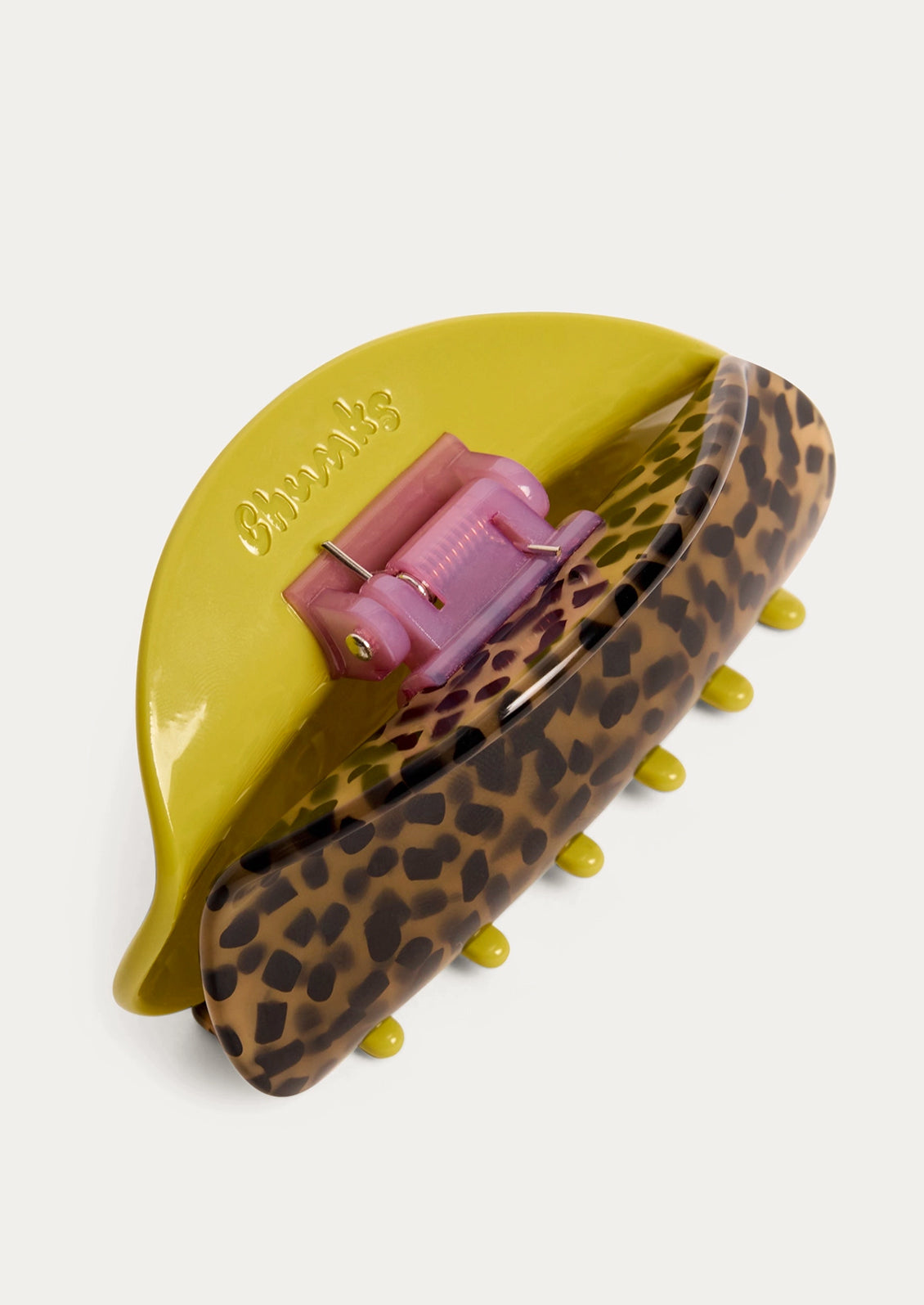 A two-tone hair claw with a chartreuse color on one side and a tortoise pattern on the other side.