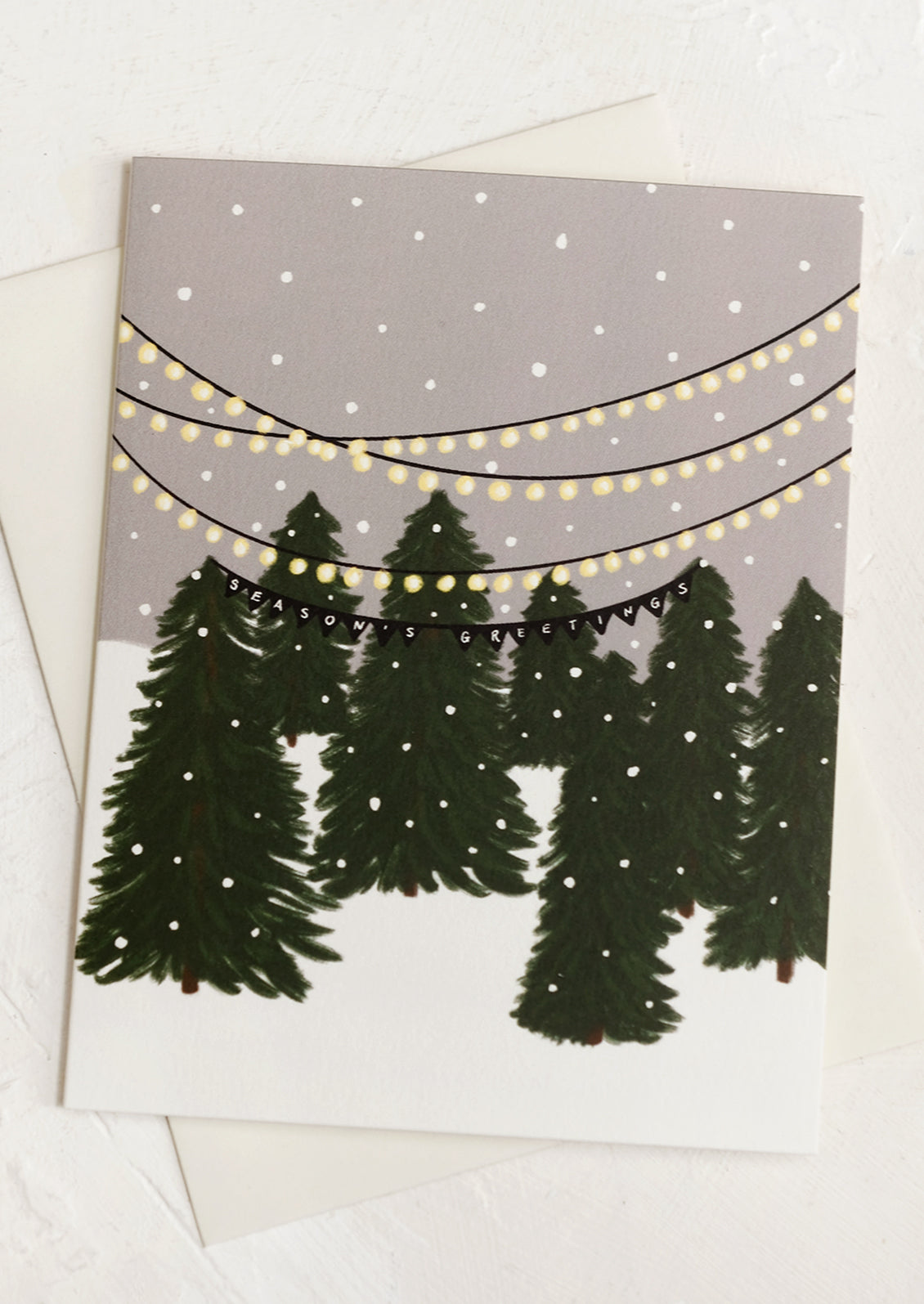 A set of holiday greeting cards with illustration of Christmas tree lot, text reads "Season's greetings".