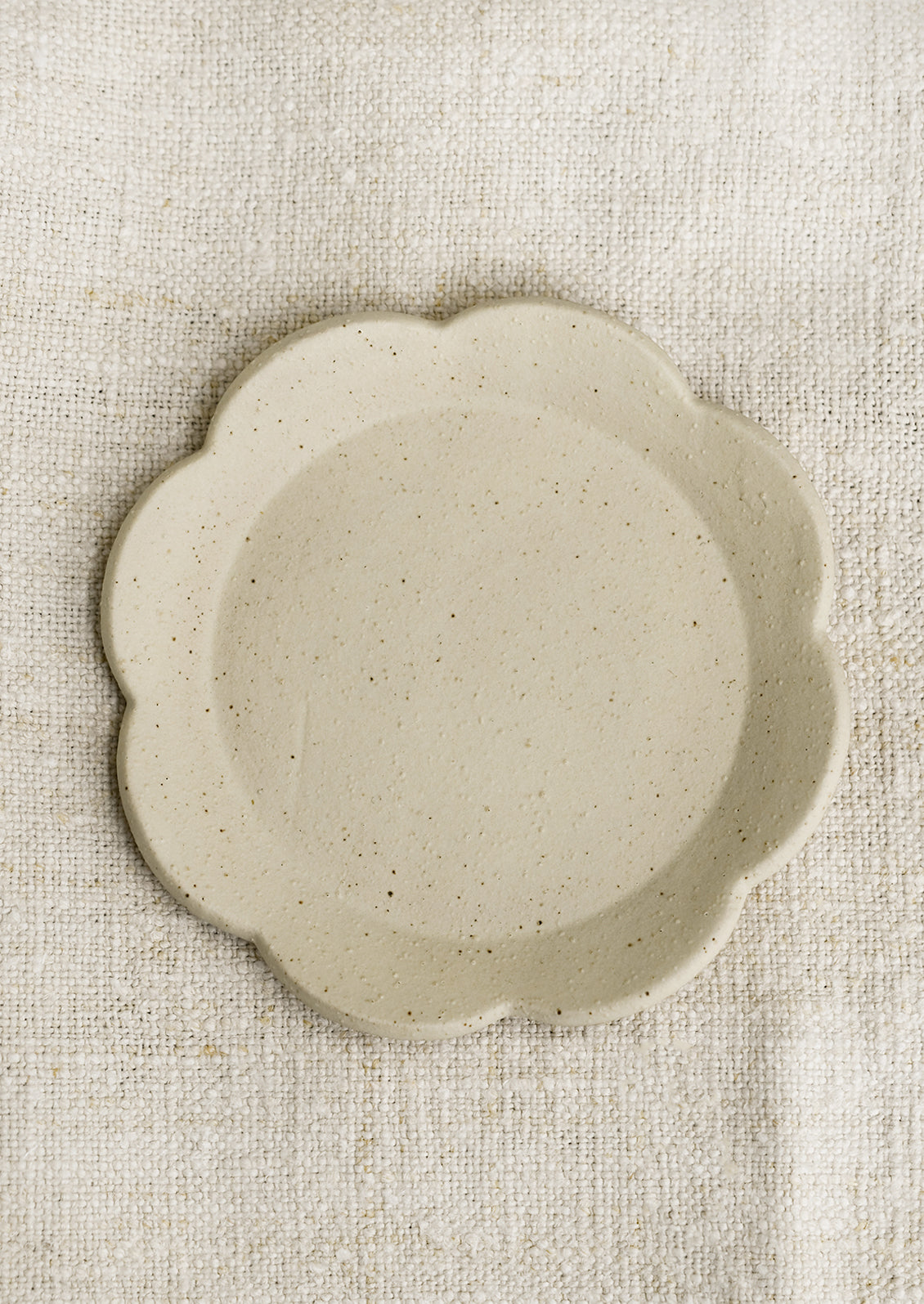 A floral shaped trinket dish in cream.
