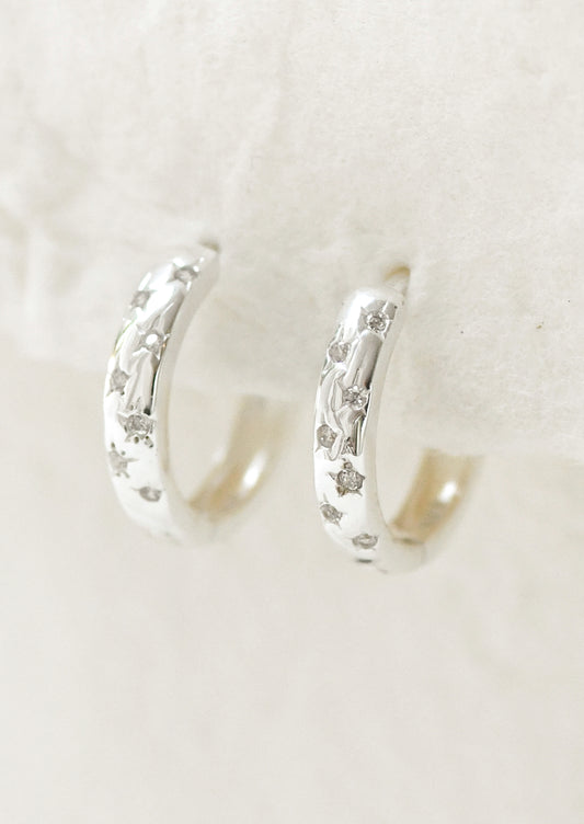 A pair of sterling silver hoop earrings with star gems.