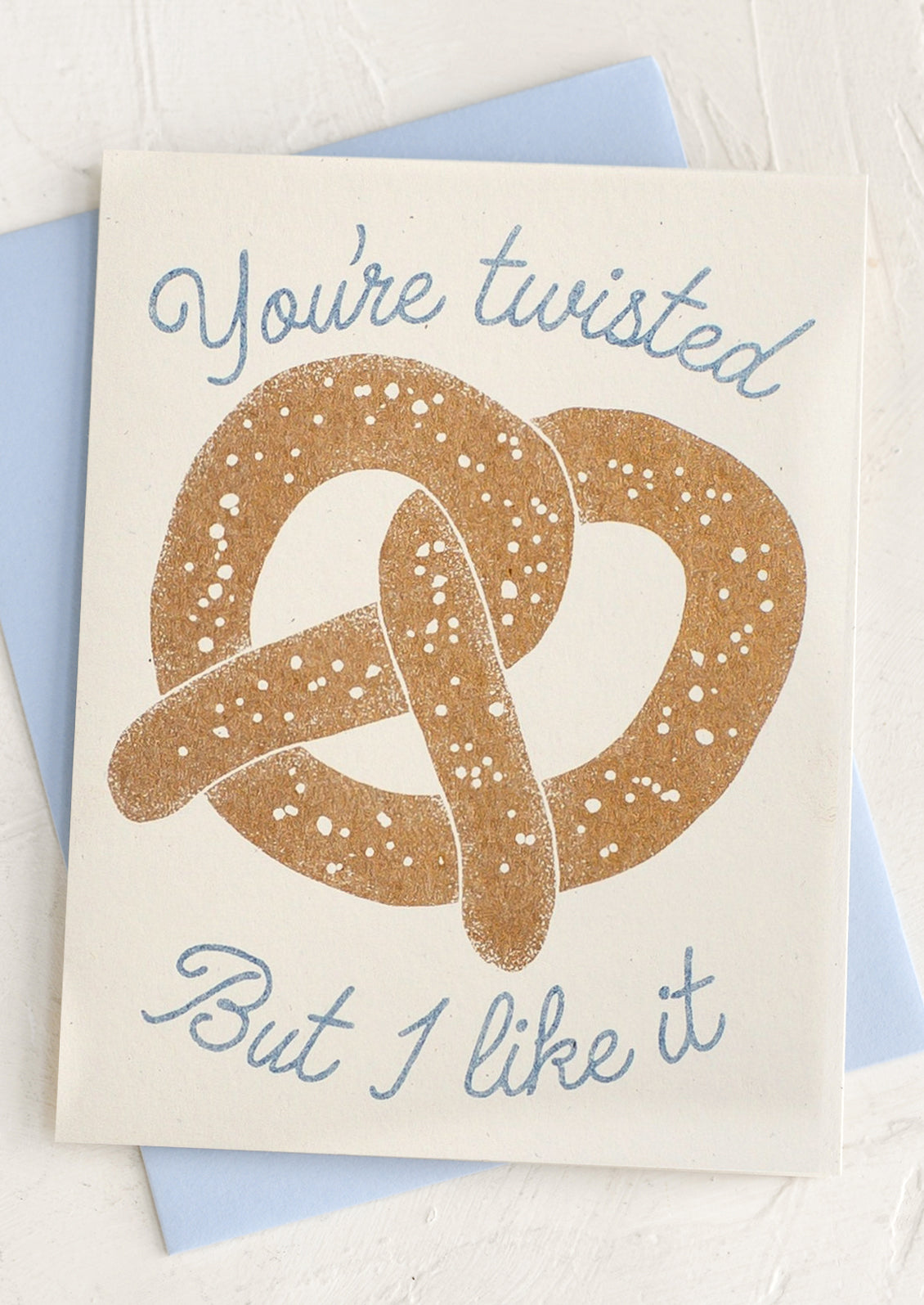 Card with a pretzel illustration and text 'You're twisted But I like it' on a light blue envelope.