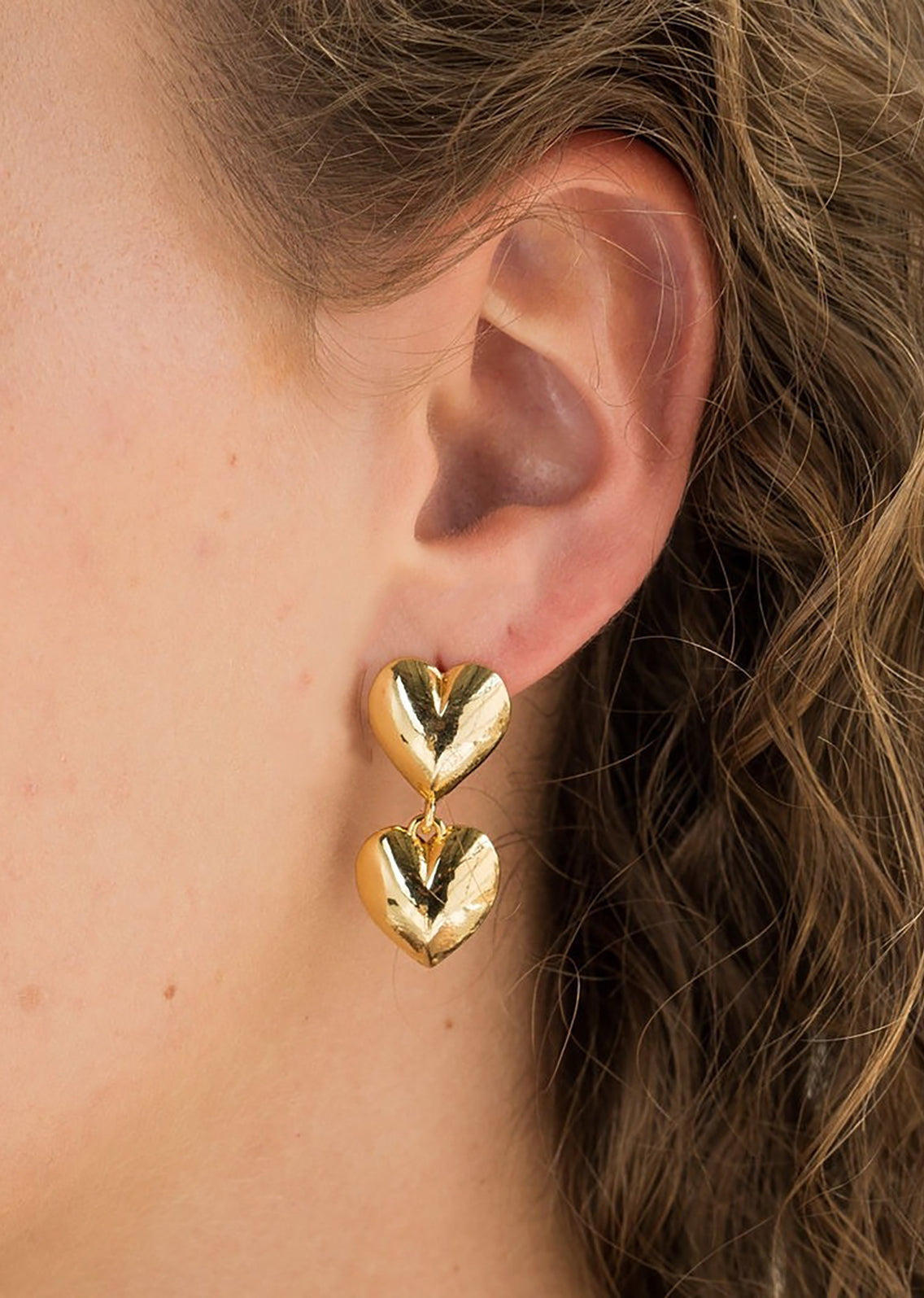 Two stacked hearts earrings in gold.