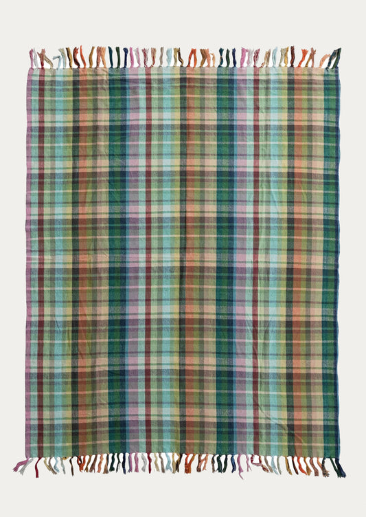Multicolored plaid blanket with tassels on a white background