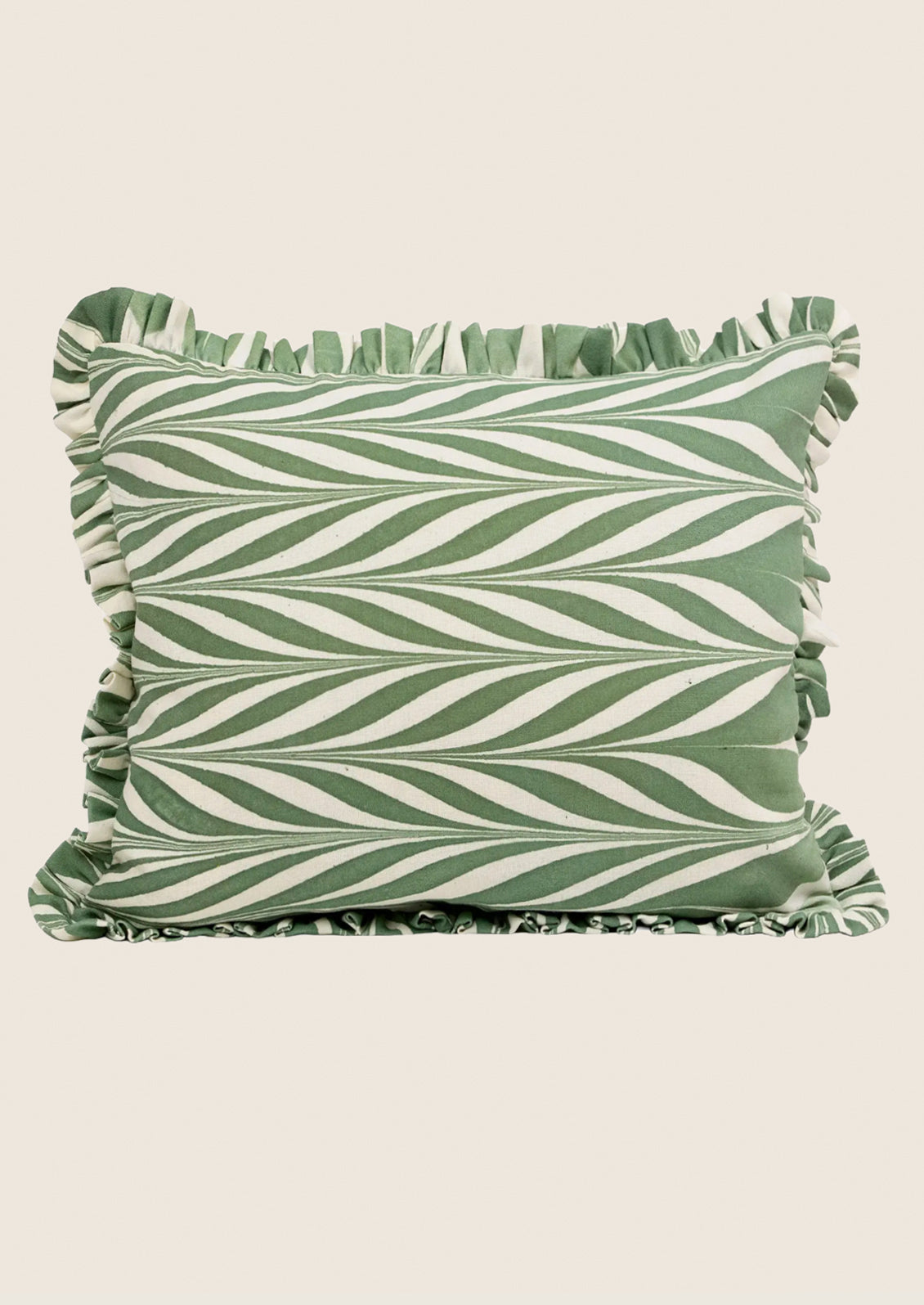 Green and white striped pillow with ruffled edges on a beige background