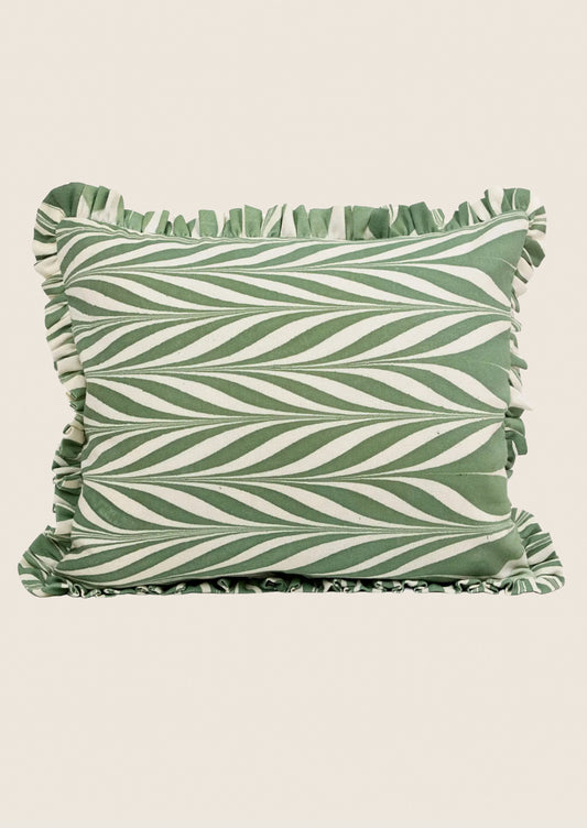 Green and white striped pillow with ruffled edges on a beige background