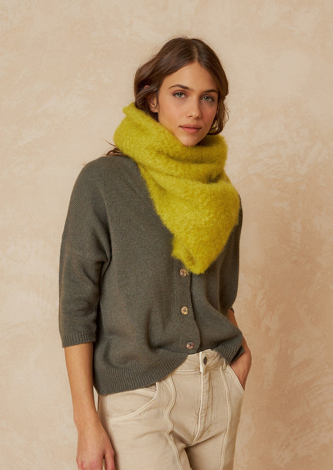 A woman wearing a fuzzy mohair scarf in chartreuse.