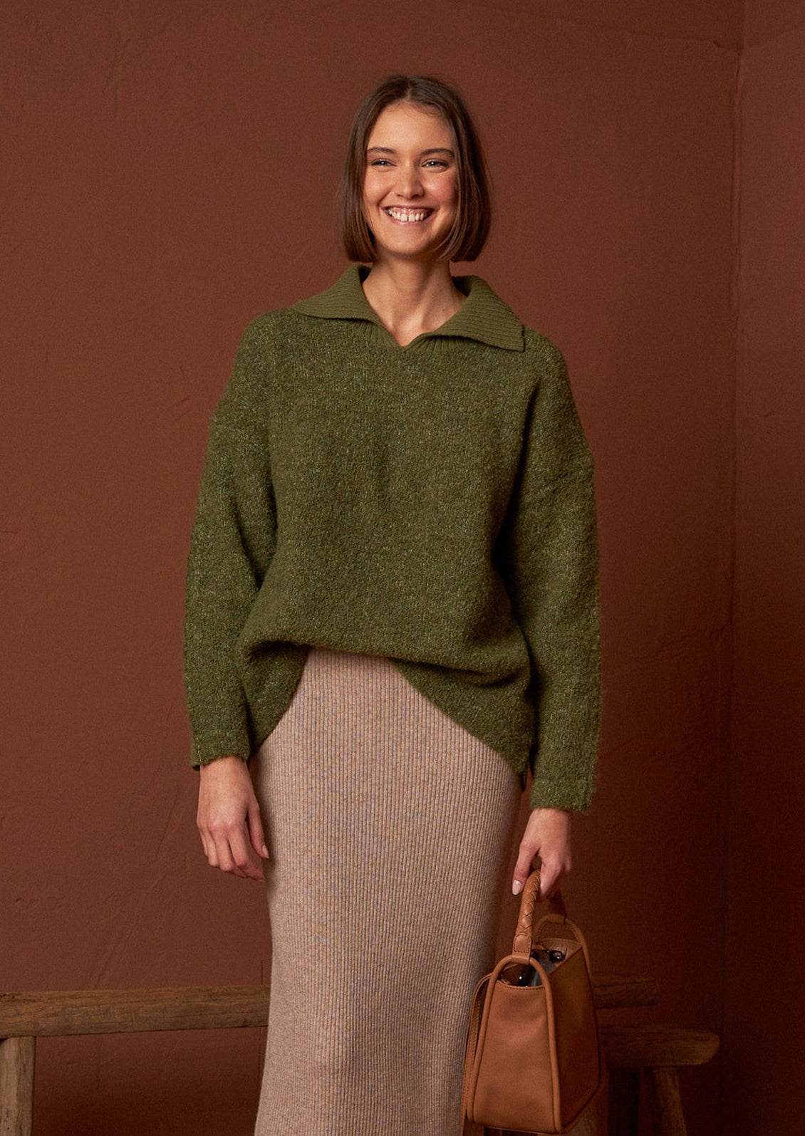 A woman wearing a polo collar fuzzy army green sweater.