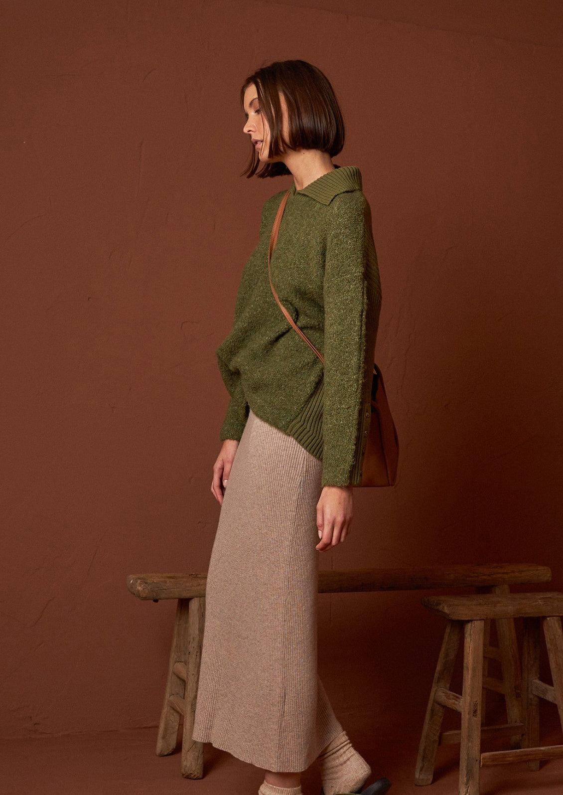 A woman wearing a polo collar fuzzy army green sweater.