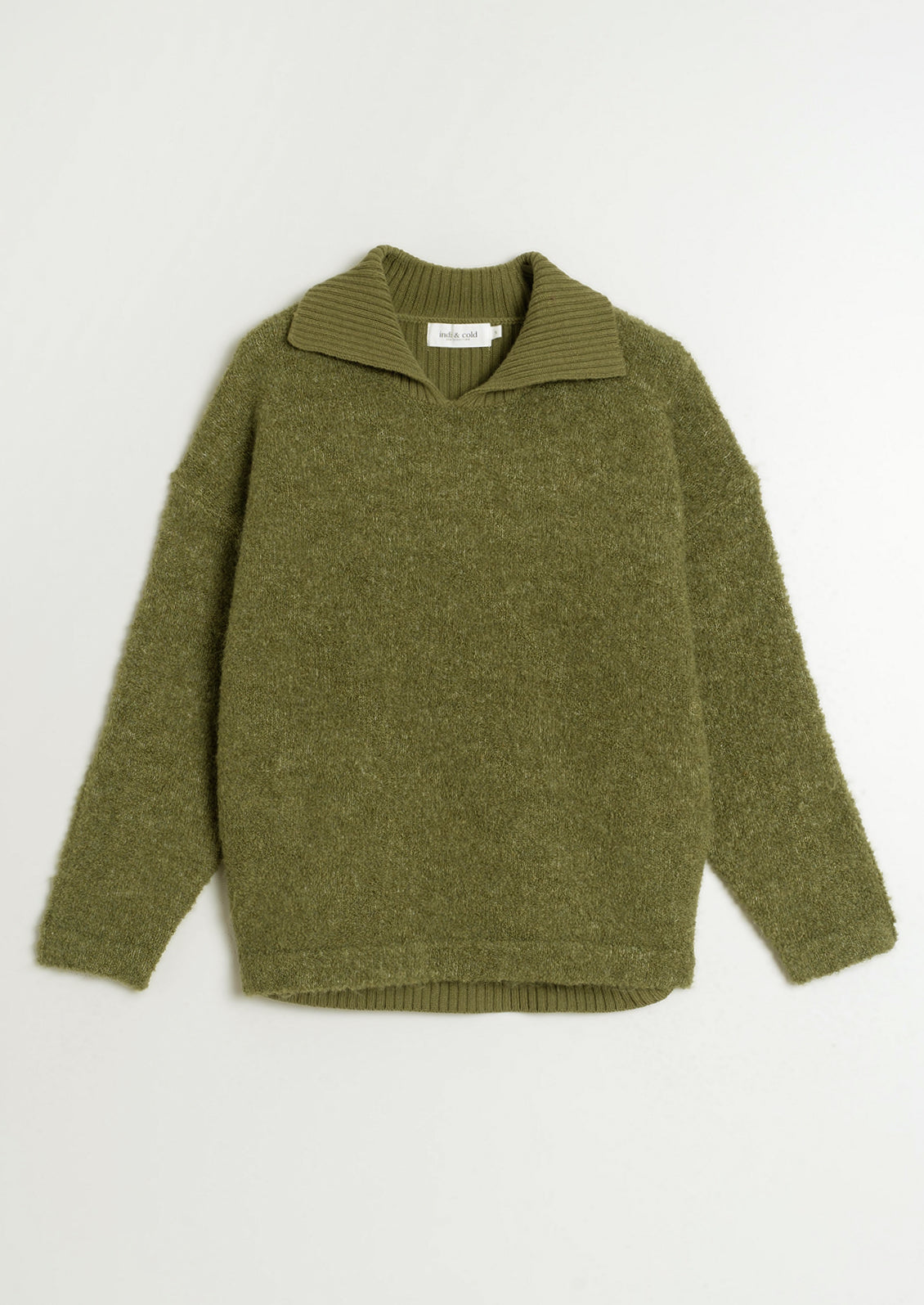 A woman wearing a polo collar fuzzy army green sweater.