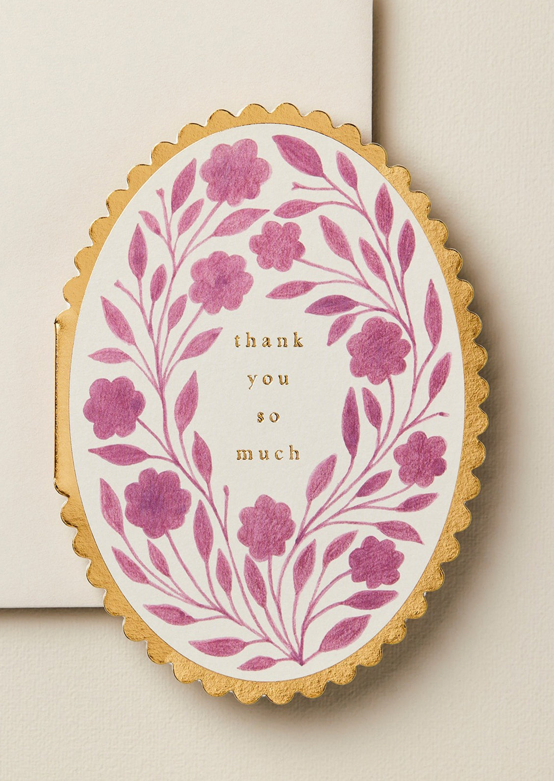 A purple floral print greeting card in oval shape with gold scalloped edges, text reads "Thank you so much".