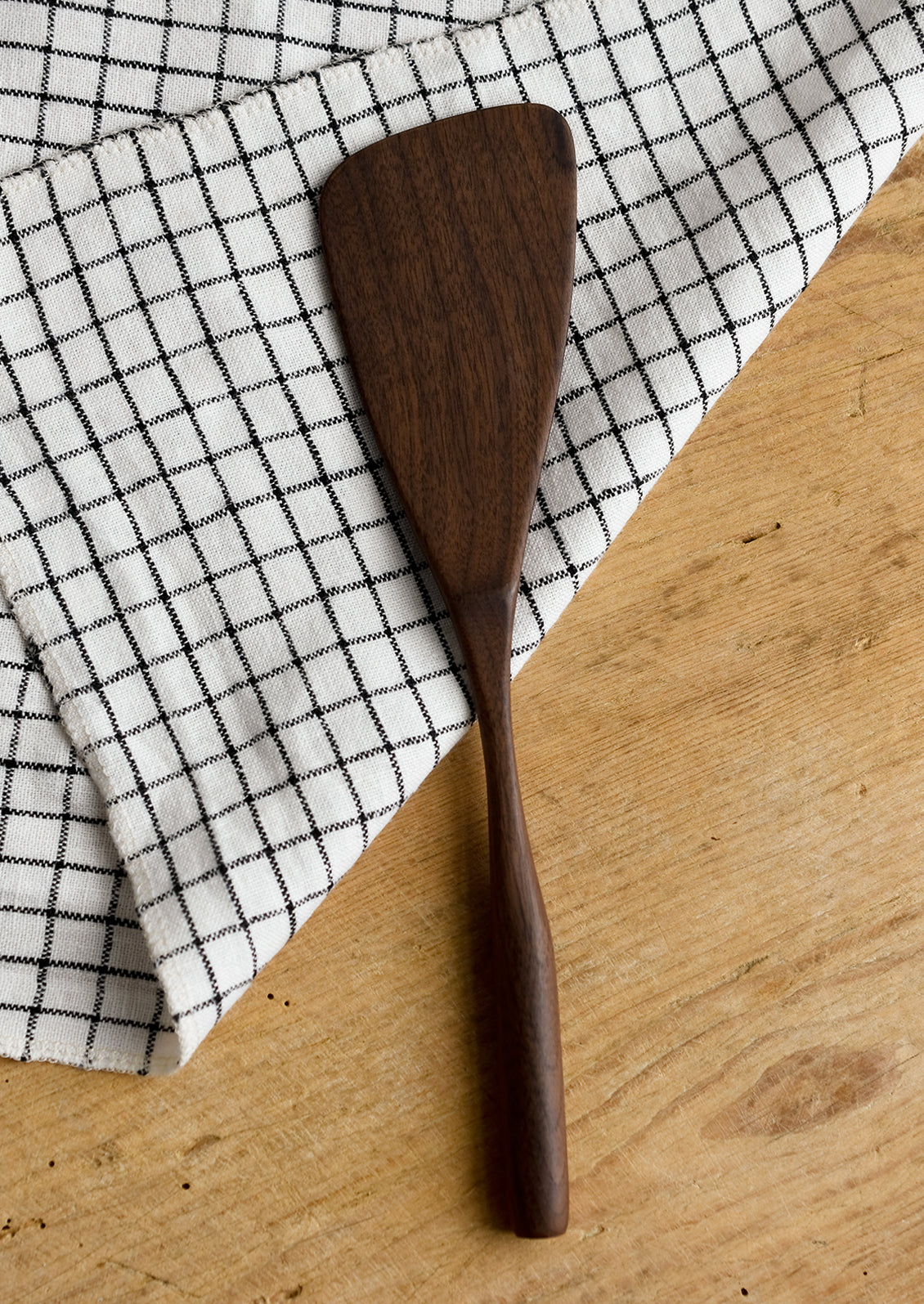 A walnut wood spatula in standard shape.