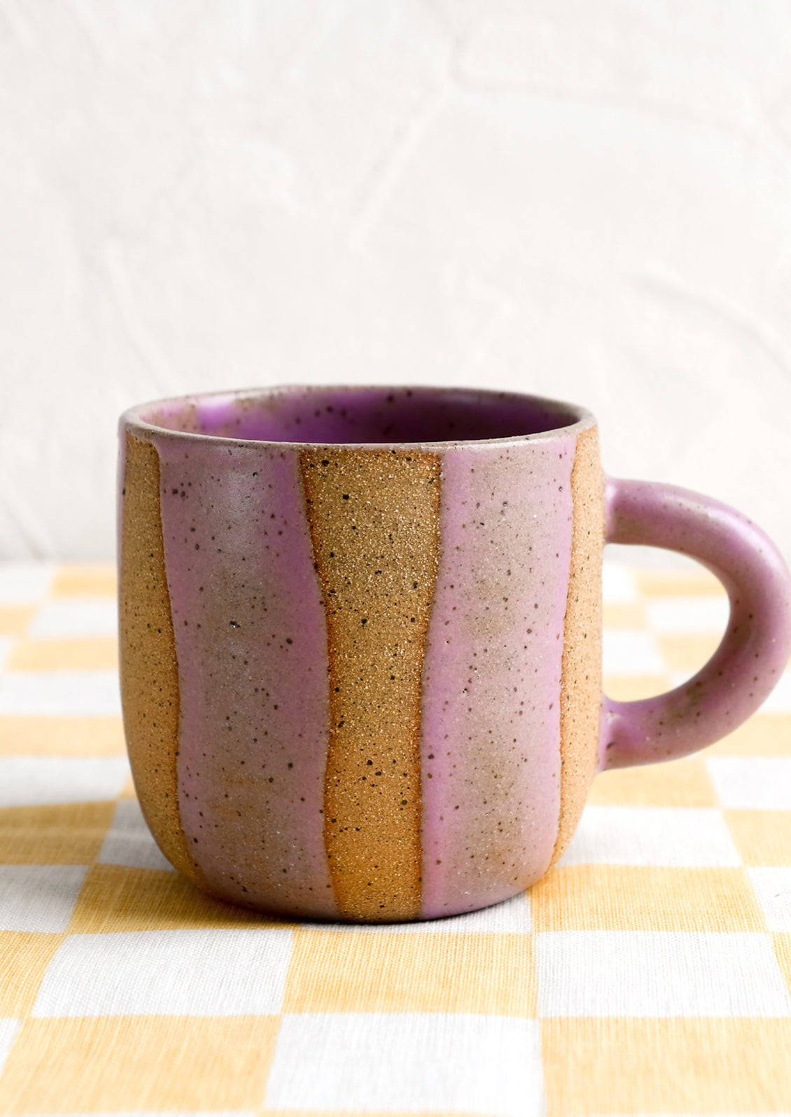 A ceramic mug with wavy stripe pattern in lavender.