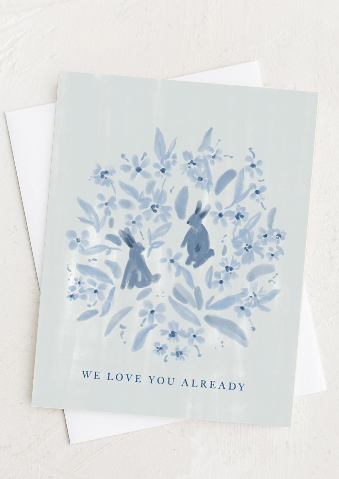 A blue bunny print card reading "We love you already".