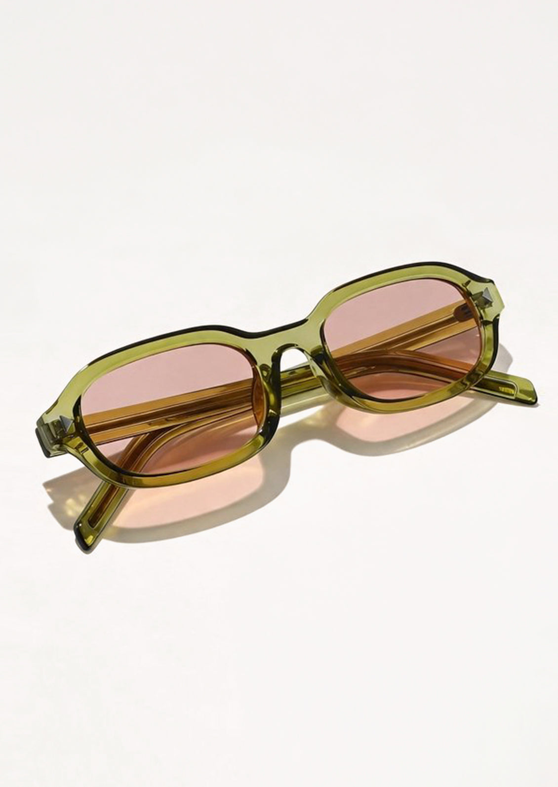 A pair of square sunglasses with a green frame and pink lenses.