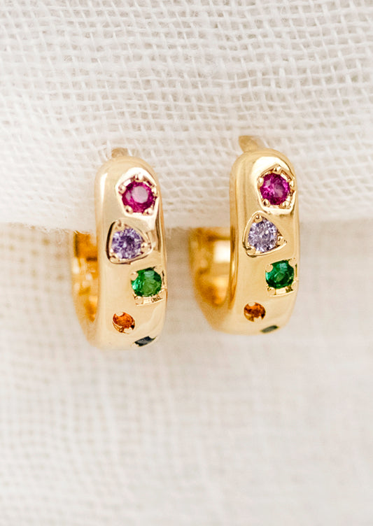 A pair of gold hoops adorned with colorful gems.