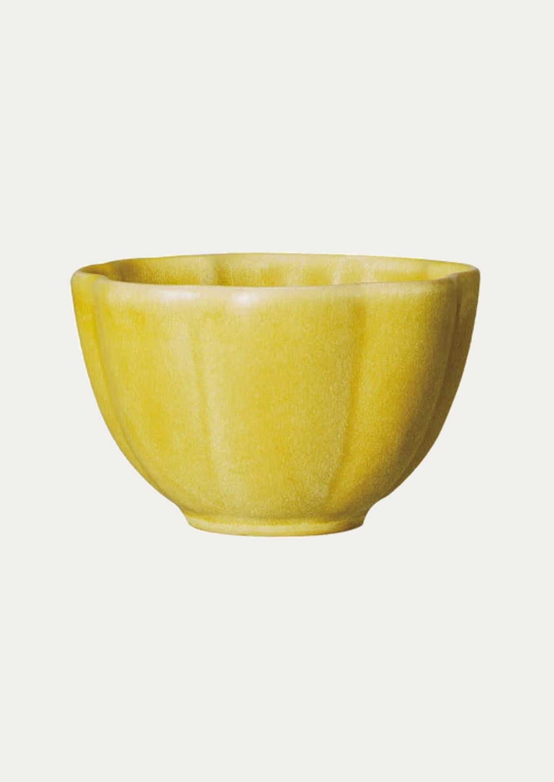 A ceramic snack bowl with scalloped shape in yellow.