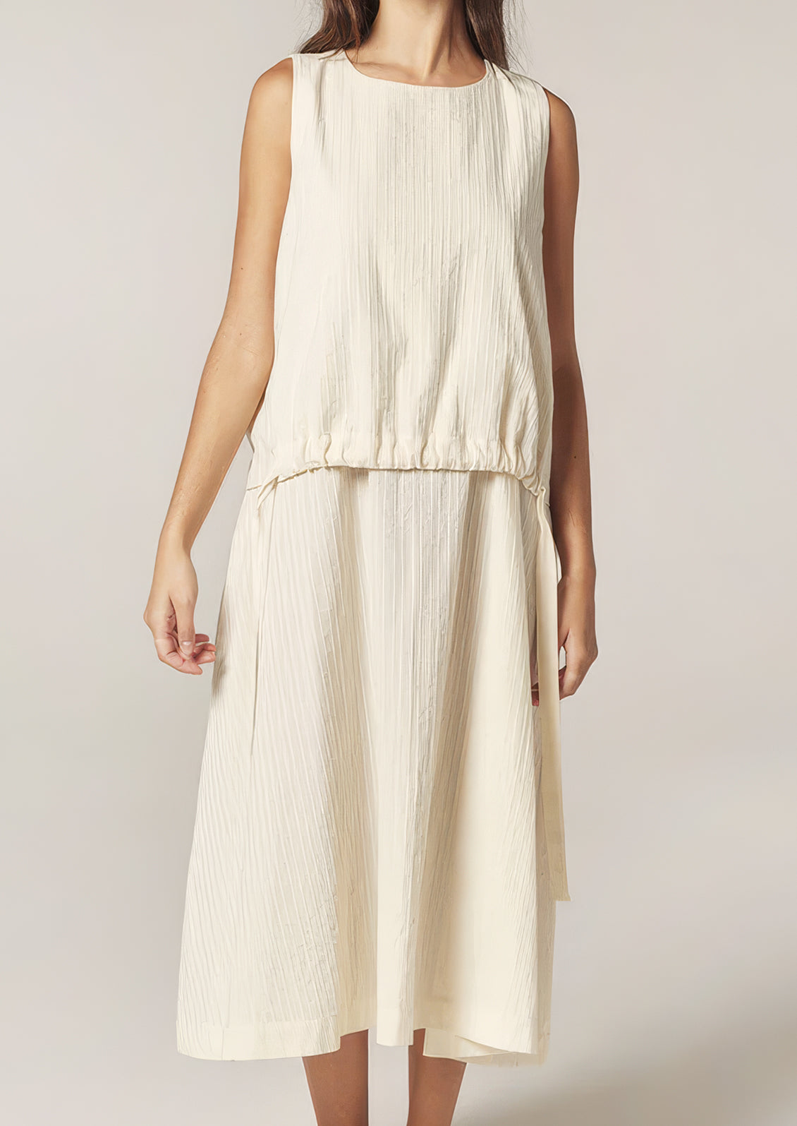 A person wearing a cream cotton dress with tonal stripe pattern.