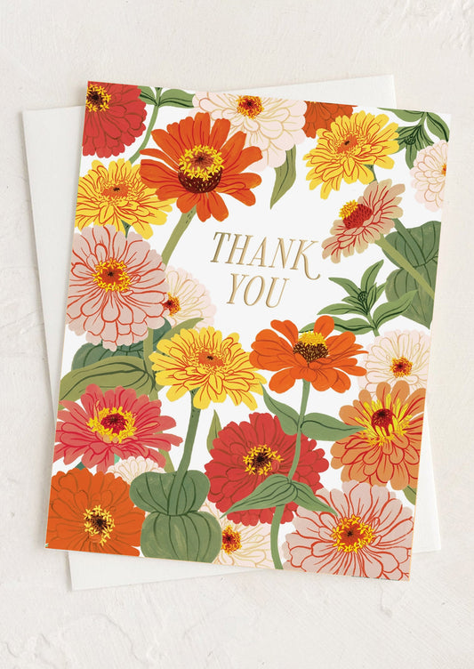 A zinnia print greeting card with gold "Thank you" text.