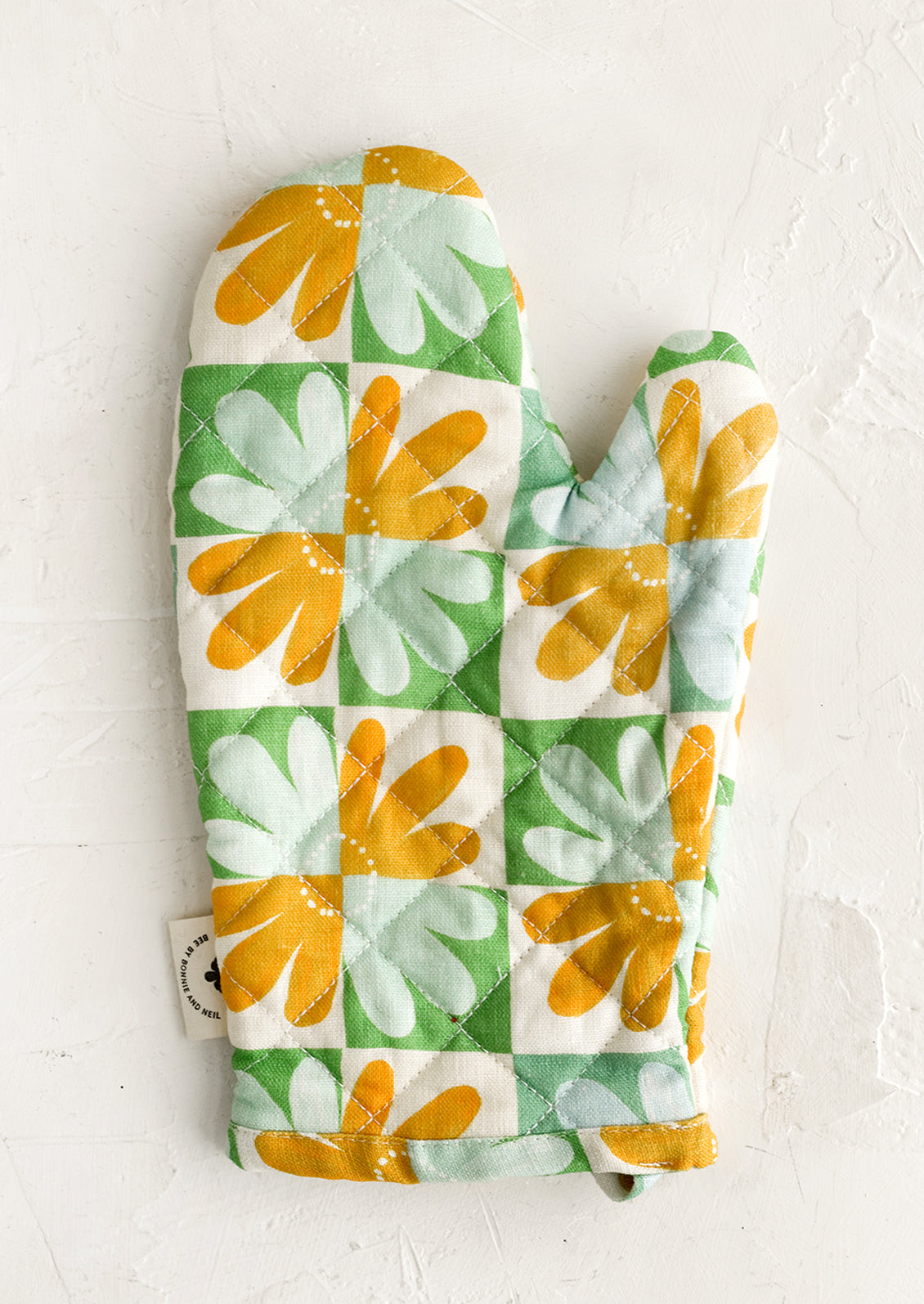 A retro floral print quilted oven mitt in mint, yellow and green.