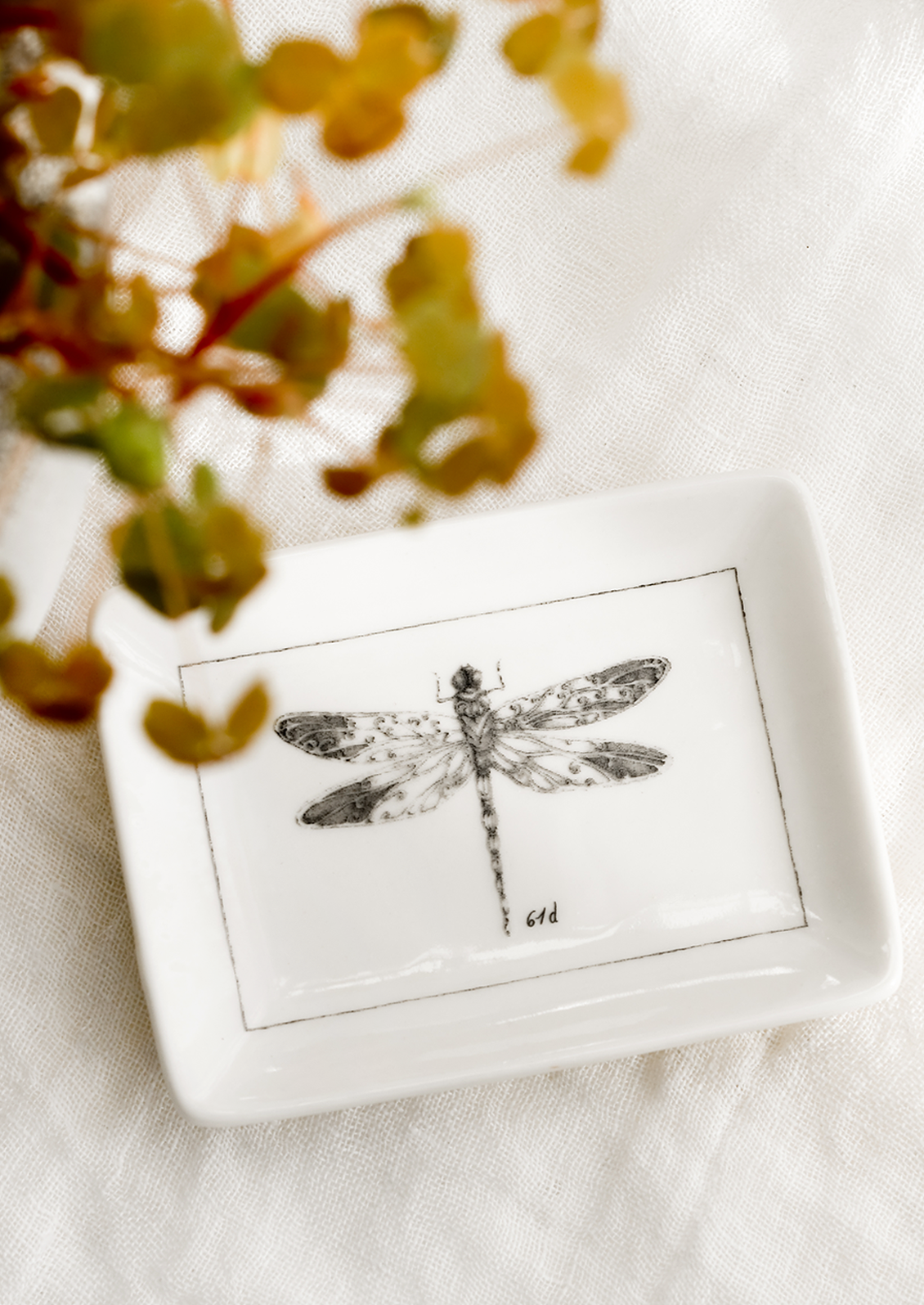 A black and white trinket dish with dragonfly.