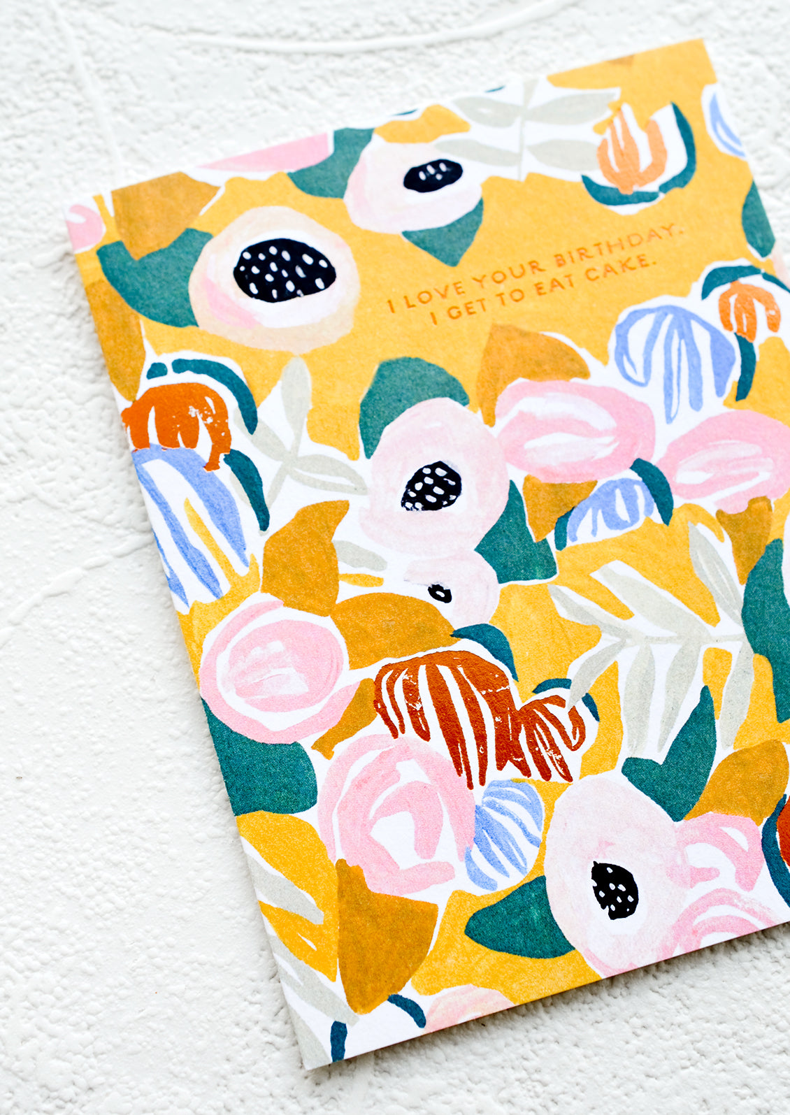 A multicolor floral print birthday card with copper text.